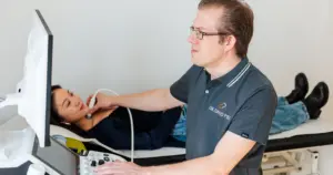 Dr. Piel untersucht Schilddrüse mit Ultraschallgerät