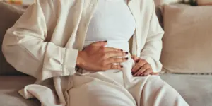 Frau mit Schmerzen wegen Zyklusstörung